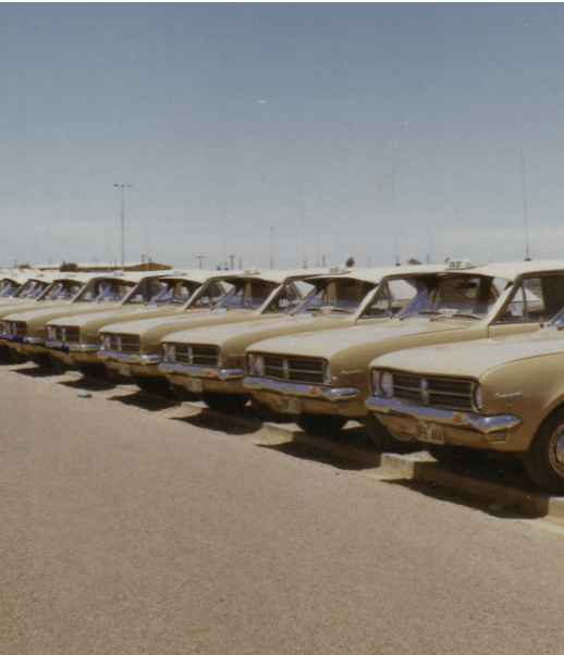 A row of cream Des's taxis lined up in Whyalla in the 1970s